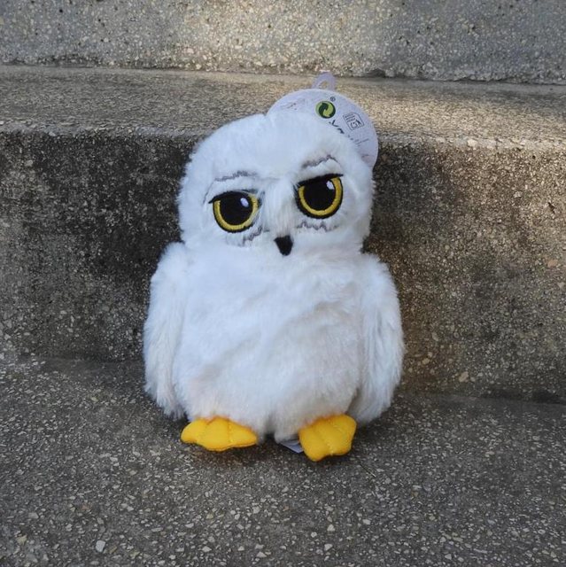 White plush owl on stone steps, product photo